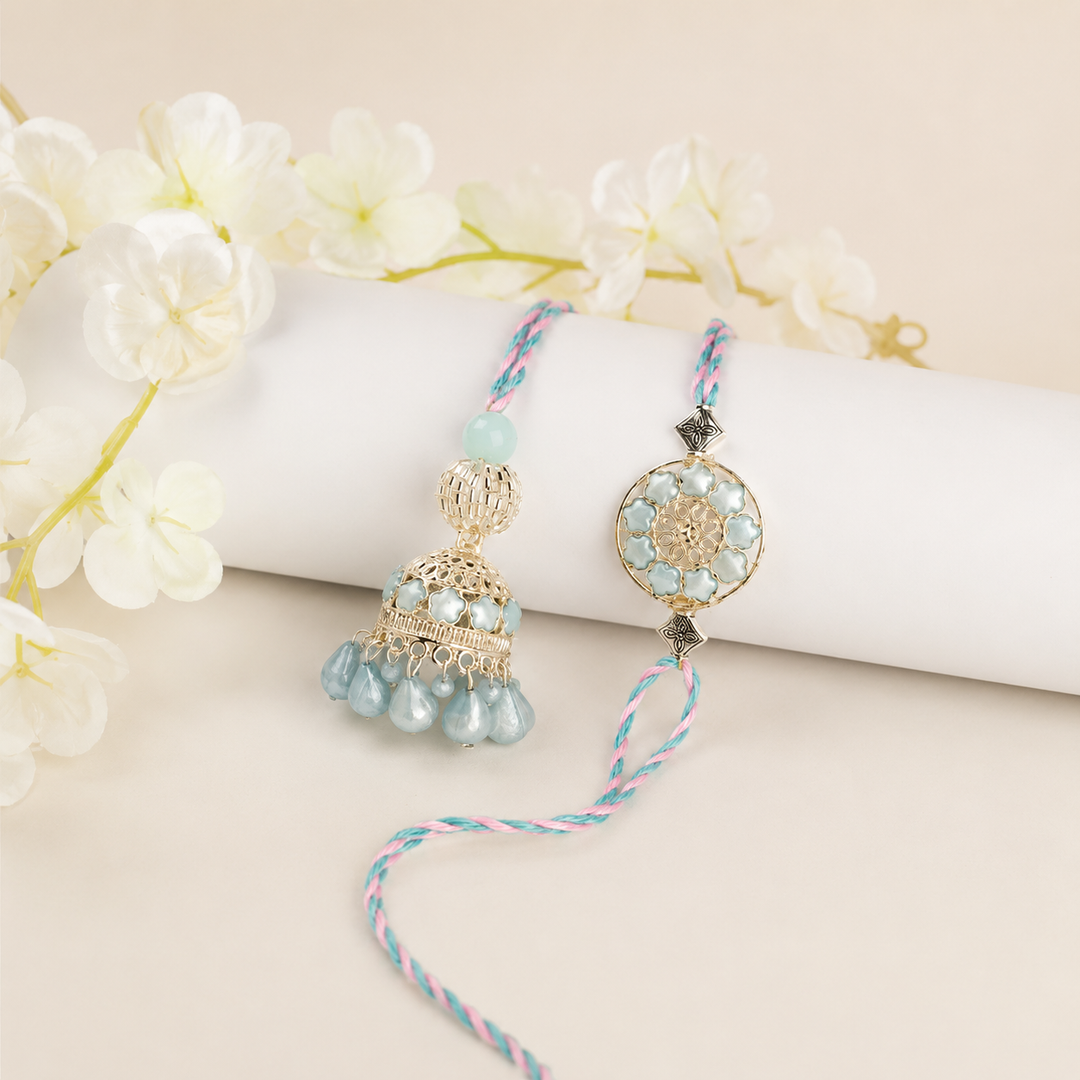 Decorative hanging with beads and gold elements on a white surface with flowers in the background