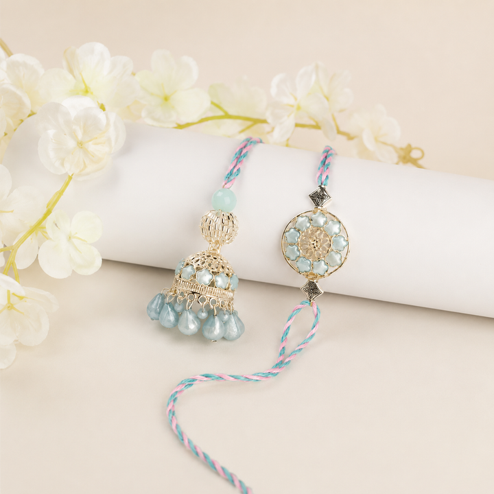 Decorative hanging with beads and gold elements on a white surface with flowers in the background