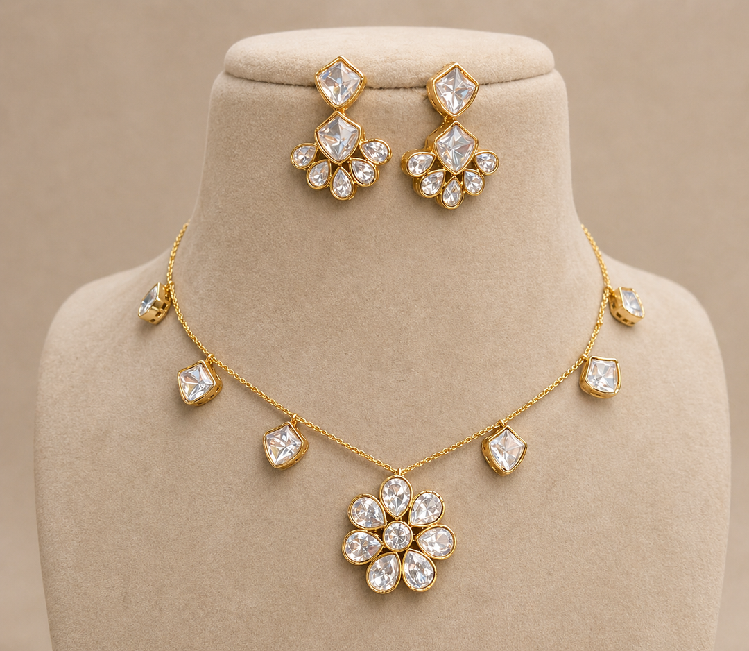 Gold necklace and earrings set on a beige mannequin bust