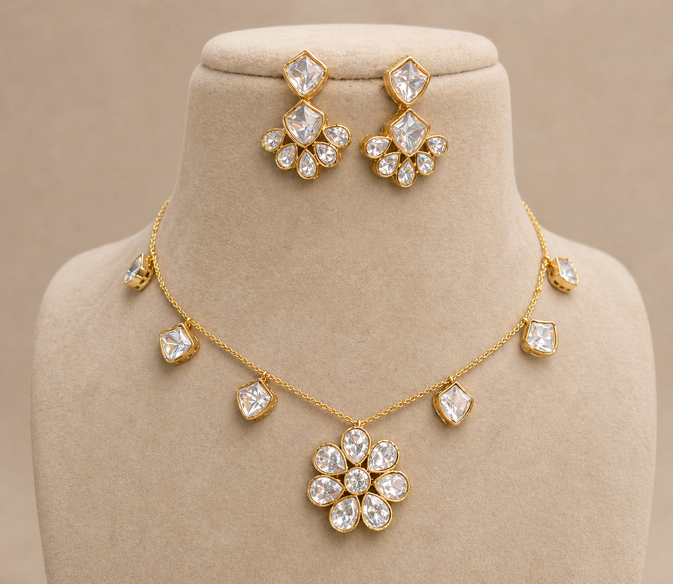 Gold necklace and earrings set on a beige mannequin bust