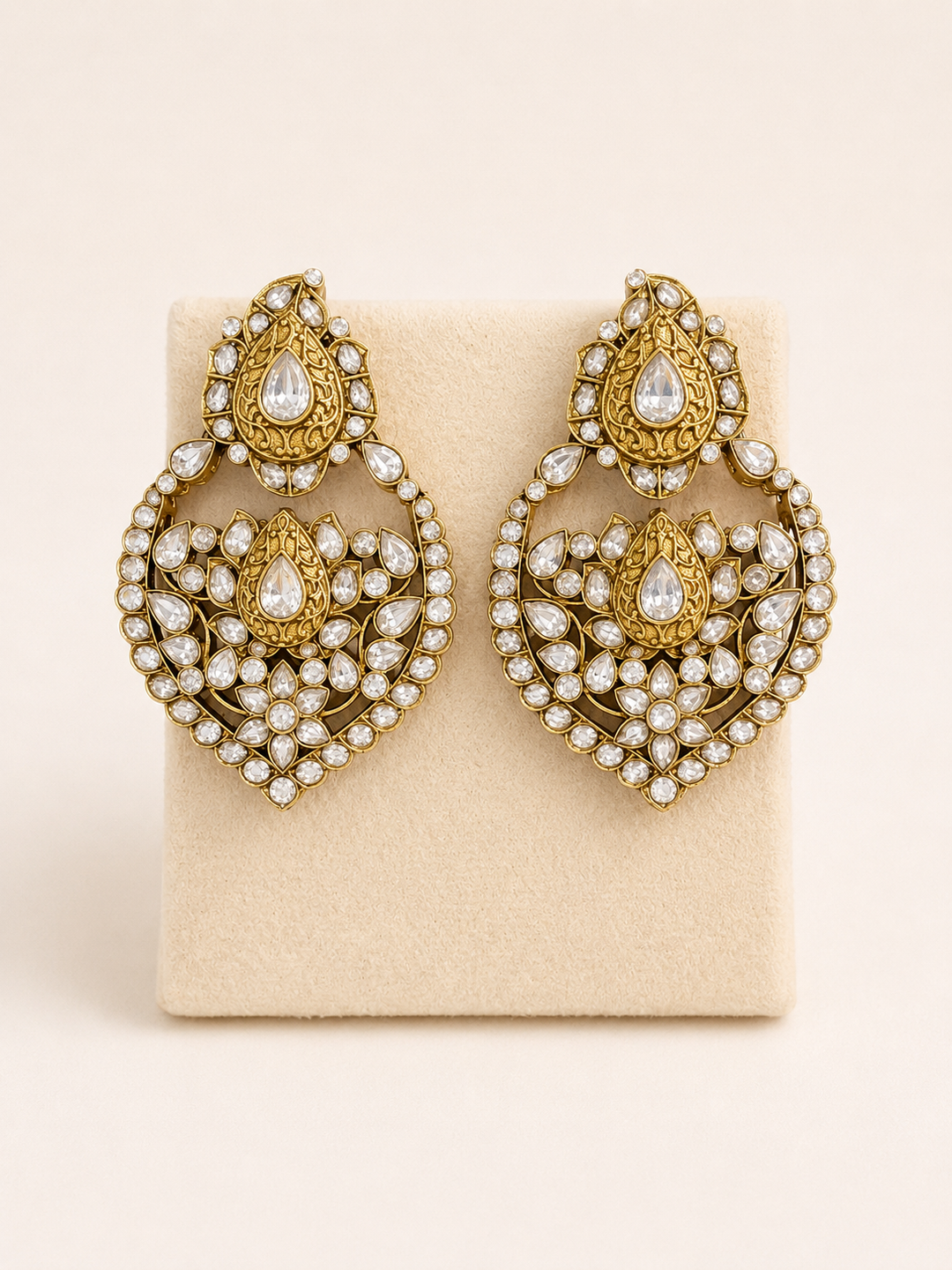 Gold and pearl earrings on a beige card