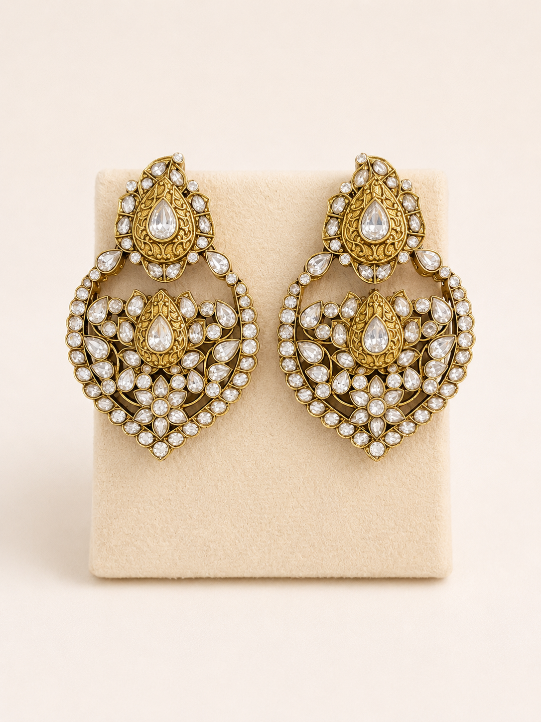 Gold and pearl earrings on a beige card
