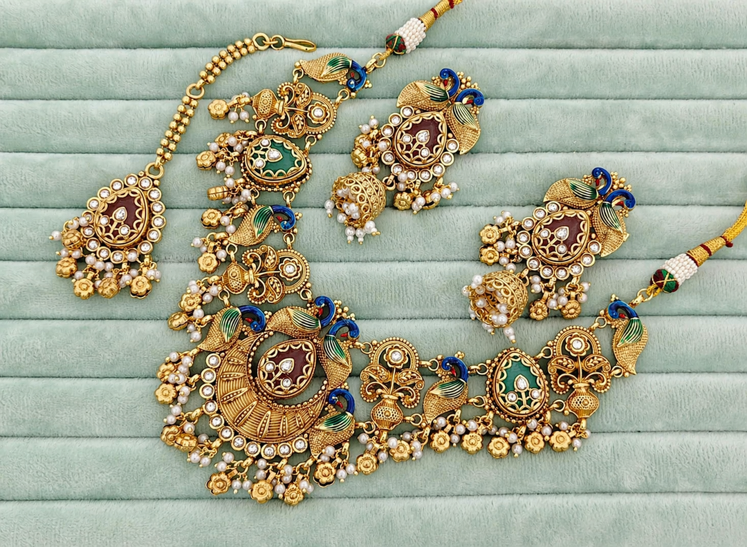 Ornate gold necklace with gemstones on a light green fabric background