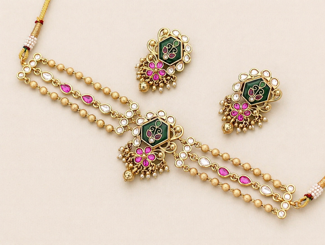 Gold necklace with pink and green gemstones on a beige background