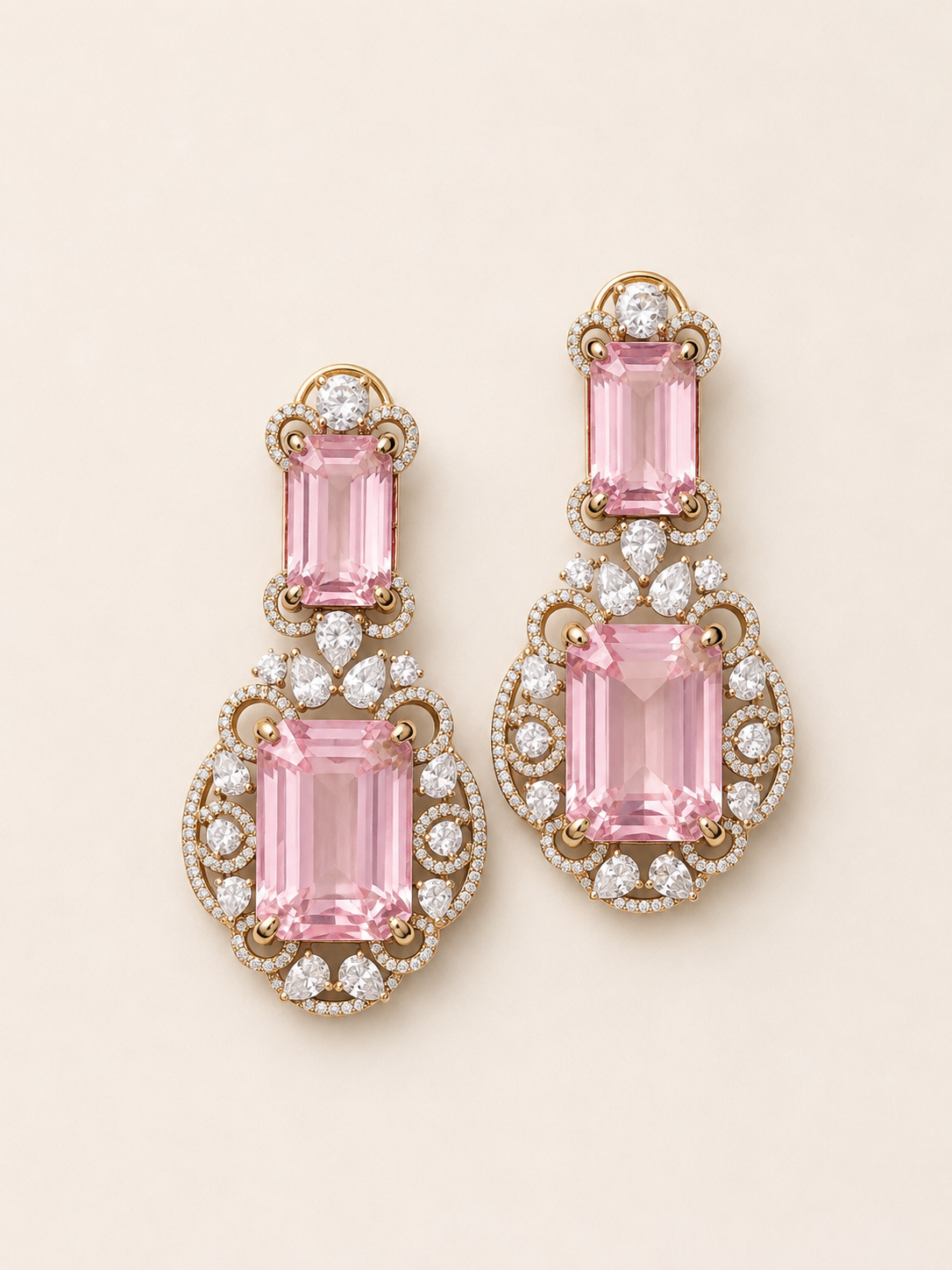 Pair of pink gemstone earrings with gold and diamond accents on a light beige background