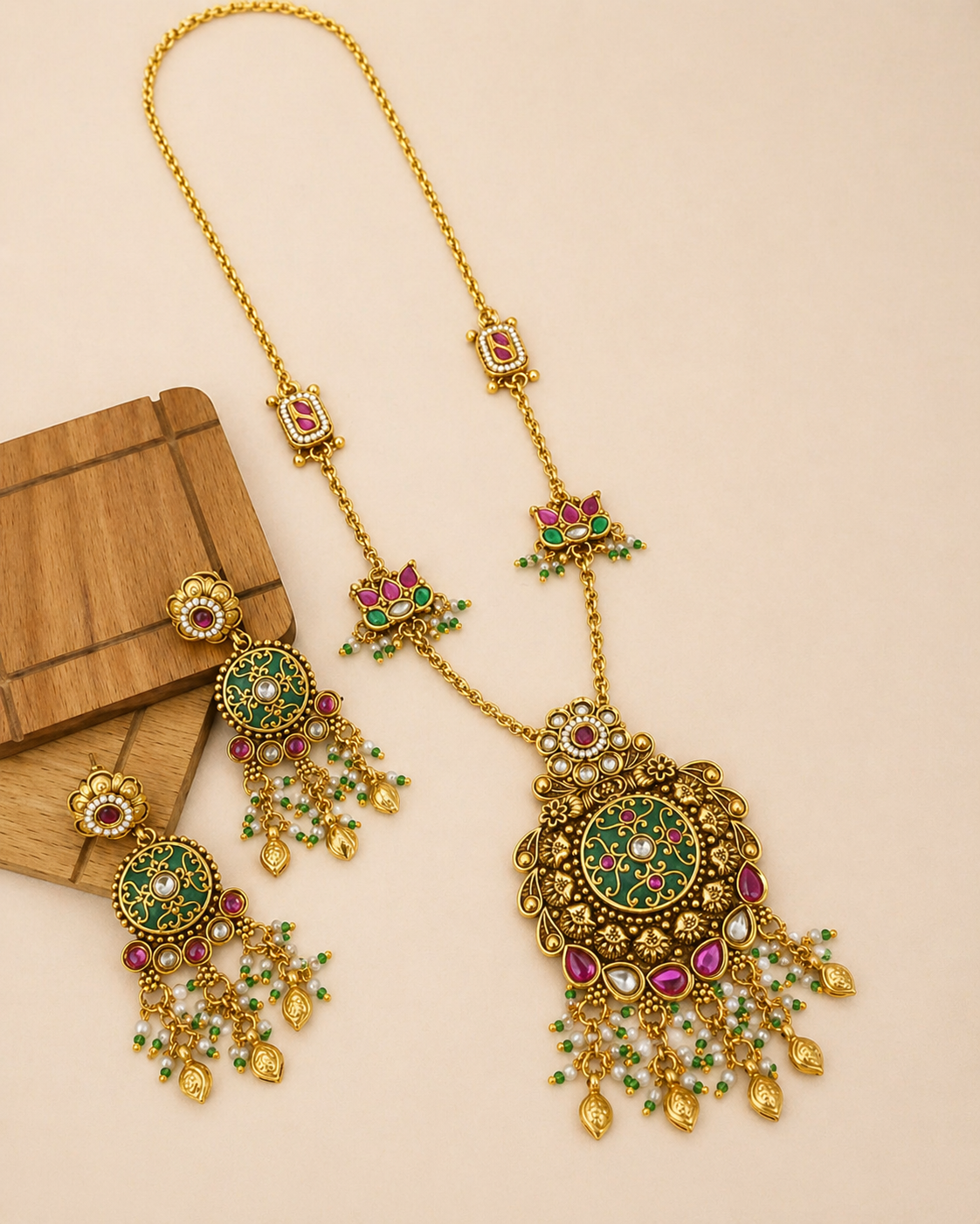 Gold necklace set with earrings on beige background