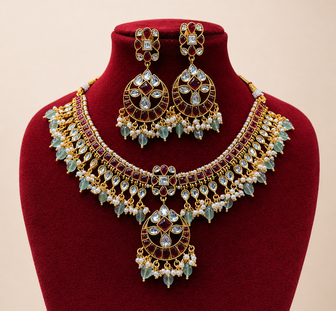 Ornate gold necklace and earrings set on a red velvet stand with a beige background